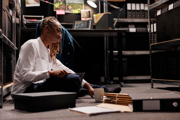A student studying in a college library surrounded by books and digital resources.