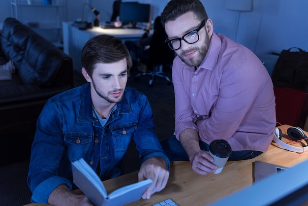 A student working at a tech company during his internship. The mood should be collaborative and focused on learning and making progress on tasks assigned by a supervisor.