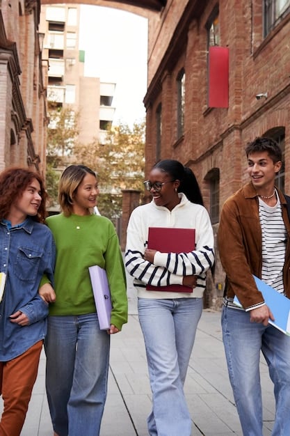A group of diverse students happily walking on a college campus, highlighting the importance of campus visits and personal experience in choosing a school.