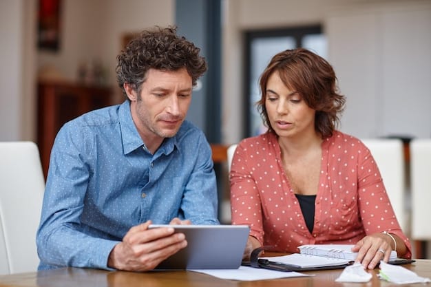 A couple looking at a budget spreadsheet on a tablet, with one person pointing and explaining while the other listens attentively.