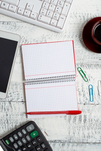 A close-up of a calculator and a handwritten notepad with calculations related to unemployment benefits. The scene includes a pen and some financial documents blurred in the background.