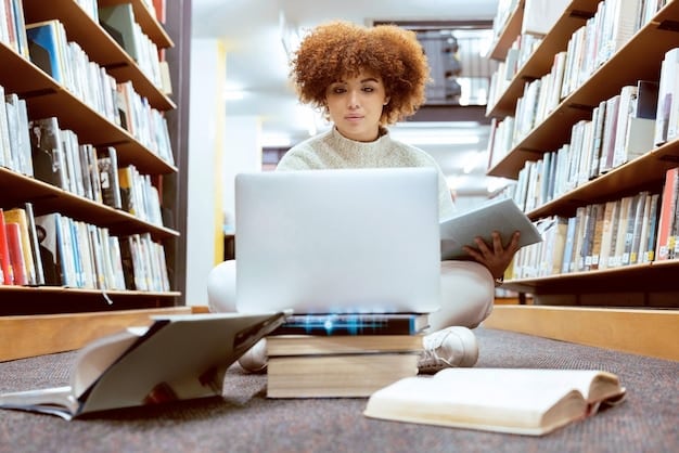 A student diligently studying in a library, surrounded by books and utilizing a laptop to enhance their research and learning process.