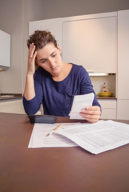 A concerned individual reviewing a stack of student loan bills, highlighting the stress and challenges associated with student debt.
