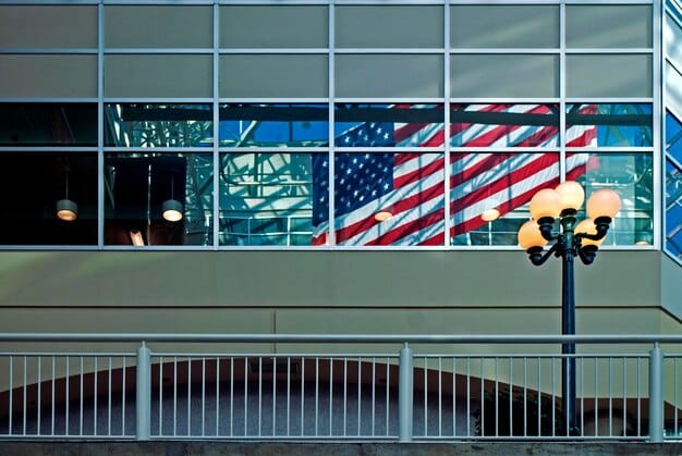 A close-up shot of a government building entrance with the American flag waving in the background, focusing on the architectural details and the official signage.