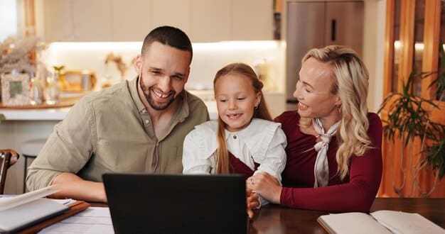 A happy family using a laptop to prepare their taxes at home, highlighting the Earned Income Tax Credit (EITC) and its positive impact on their finances. The scene depicts a comfortable and well-lit living room, with tax documents and a calculator on the table.
