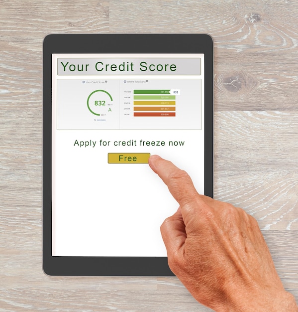 A close-up shot of a credit score report displayed on a tablet, with a magnifying glass hovering over the score. The background is blurred, emphasizing the importance of the credit score.